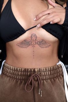 a woman's stomach with an angel tattoo on her belly and the word love written in