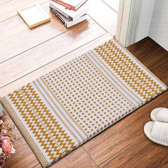 a pair of slippers sitting on the floor next to a yellow and white rug