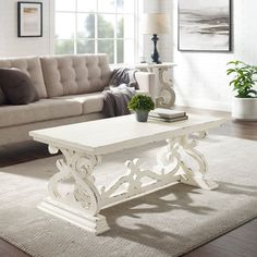 a white coffee table sitting on top of a rug in a living room next to a couch