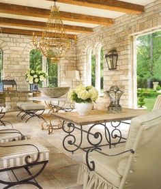 a living room filled with lots of furniture and a chandelier hanging from the ceiling