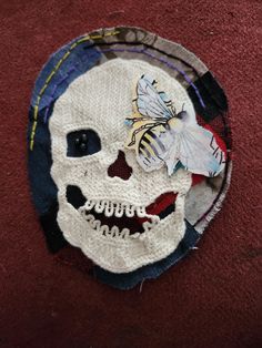 a knitted skull with a bee on it