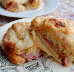 a sandwich cut in half sitting on top of a white and red plate with other plates behind it