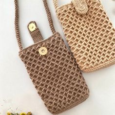 two crocheted purses sitting next to each other on a white surface with flowers