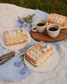 some waffles and coffee on a table with blue gingham cloth in the background