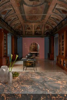 an ornately decorated room with marble flooring and wooden bookshelves on the walls