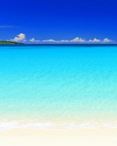 the ocean is blue and clear with white sand