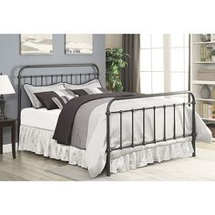 the bed is made with metal and has white sheets, black trimmings, and pillows