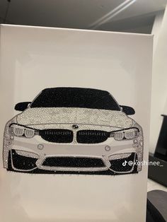 a white card with a black and white car on it's front, in the shape of a bmw