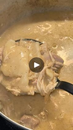 a pot filled with meat and gravy being stirred by a ladle in it