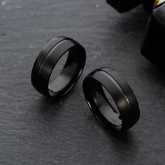 two black ceramic rings sitting next to each other on top of a gray tablecloth