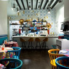 the interior of a restaurant with colorful tables and chairs