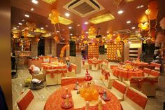 a banquet hall with orange and yellow decorations