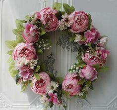 a wreath with pink flowers and green leaves