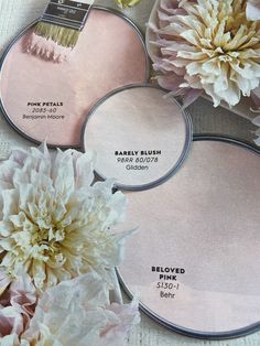 three round mirrors with different shades of pink and white flowers on top of each mirror