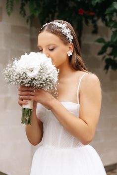 a woman in a white dress holding a bouquet of flowers