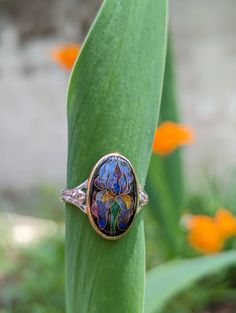 For me the Iris is a symbol of my mother and her love of gardening. She would work tirelessly to plant iris bulbs, her favorite flower, in the preparation for spring. Irises are also associated with symbols of hope, wisdom, trust and valour. This lovely ring is made from glass enamel, fine silver, 24k and 22k gold, and peach topaz set in a sterling silver band. This ring is made to order to your perfect fit and will take 2-4 weeks from order to shipping to make. Plant Iris Bulbs, Symbols Of Hope, Iris Bulbs, Iris Jewelry, Iris Ring, Favorite Flower, Hope Symbol, Irises, Lovely Ring