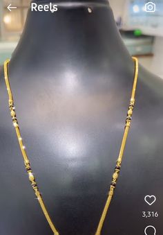 the gold necklace is being displayed on a mannequin