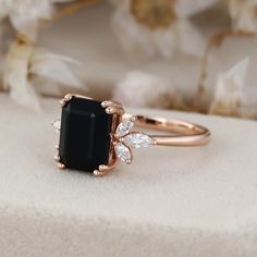 Embrace the enchanting allure of our Emerald Cut Black Onyx Diamond Ring, meticulously crafted in lustrous 14K rose gold. Onyx Rings Women, Onyx Diamond Ring, Black Onyx Engagement Ring, Onyx Engagement Ring, Birthstone Rings, Side Stone Engagement Ring, Black Onyx Ring, Moissanite Jewelry, Onyx Ring