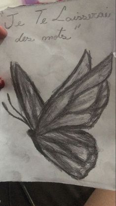 a child's drawing of a butterfly on paper with writing in spanish and english