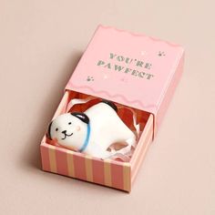 a small white cat in a pink box on a table with the words you're paffest printed on it