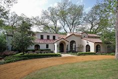 a large white house surrounded by trees and bushes