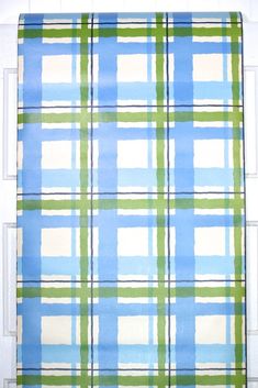 a blue and green plaid rug hanging on a door