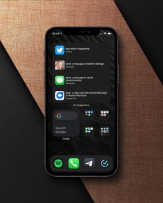 an iphone with the app icons displayed on it's screen, sitting on top of a wooden surface