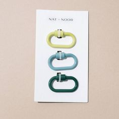 three different colored rings on top of a white card with the words nat & noor