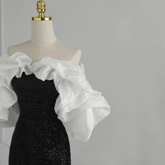 This gothic black and white wedding dress is sure to stand out from the rest. It is adorned with sequins and a ruffle that cascades down the front. The fit is flattering for all body types and the dress is sure to make a statement. ❤️CUSTOM MADE❤️ For custom made, please message us your height, bicep circumstance, bust, lower chest circumference, mid-shoulder to bust point, waist and shoulder width. How to measure? Black And White Prom Dresses, Masquerade Outfit, Black And White Gown, Dress Outfits Party, White Ruffle Dress, White Evening Gowns, Gowns Dresses Elegant, White Ball Gowns, Black Dress Formal