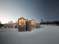 a house that is covered in snow and has two windows on the side of it