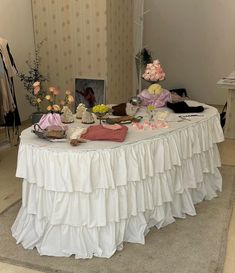 a white table topped with lots of different types of food and flowers on top of it