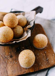 a wooden cutting board topped with lots of sugar covered donuts on top of it