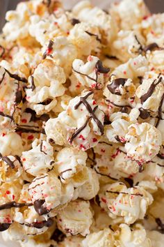 white chocolate popcorn with sprinkles and candy caned on top in a bowl