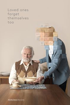 an elderly man and woman sitting at a table with food stacked on top of their heads