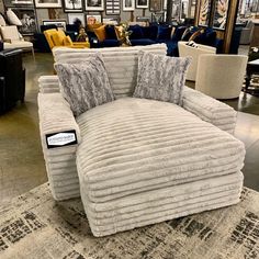 a chair that is sitting on top of a rug in a room with couches and chairs