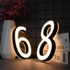 the number eight is lit up in front of a wall