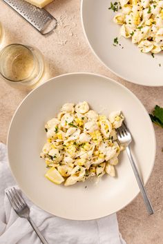 two white plates filled with pasta and vegetables