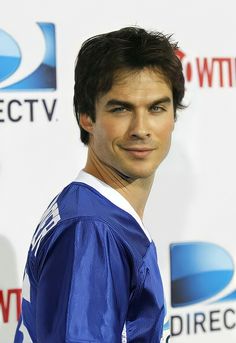 a young man in a blue jersey posing for the camera