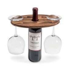 two wine glasses sitting on top of a wooden table next to a bottle of wine