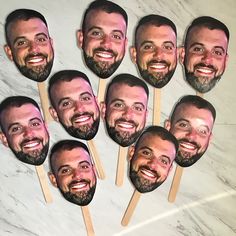 a group of men with beards on top of toothpicks in front of a marble wall