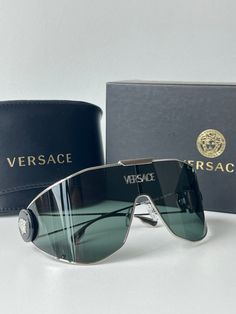 Brand new Versace VE2268 10003H Silver Medusa Shield Sunglasses. Oversized shield with medusa detailing on temples and silver metal logo across center lens. 1-14-115mm measurements. Dark Green lens. Comes with box, case, cloth, and all papers. Medusa Shield, Wedding Glamour, Luxury Luggage, Sunglasses Oversized, Green Lens, Sunglasses Logo, Coconut Rice, Versace Accessories, Stylish Glasses