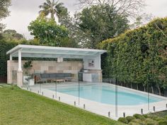 an outdoor swimming pool surrounded by greenery and fenced in area with seating areas