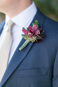 a man in a suit with a boutonniere and flower on his lapel