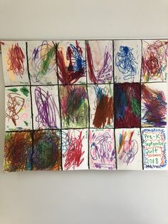 a group of children's drawings on a wall hanging from a white board with writing in it