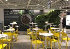 the interior of a restaurant with yellow chairs and tables