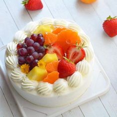 a white cake topped with fruit on top of a table