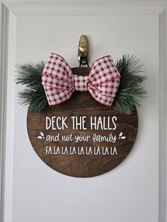 a wooden sign that says deck the hall and not your family with a bow tie on it