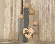 a wooden sign that says the smiths hanging on a door handle with some balls around it