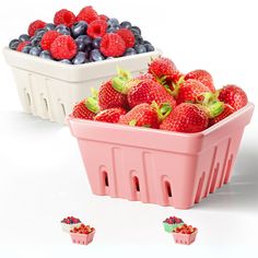 some strawberries and blueberries are in a pink container