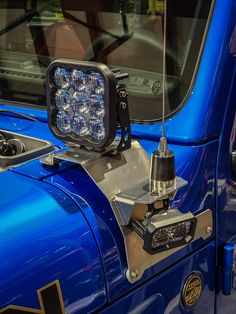 a close up of a blue truck with lights on it's headlamps